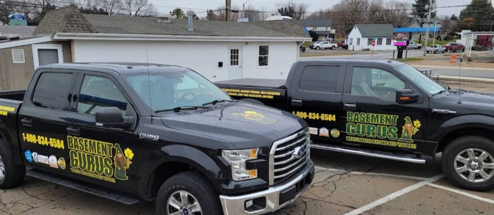 Two Basement Gurus trucks outside the shop